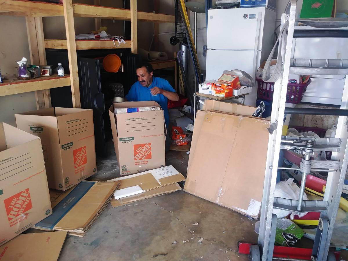 Han's Moving mover packing boxes in a home garage