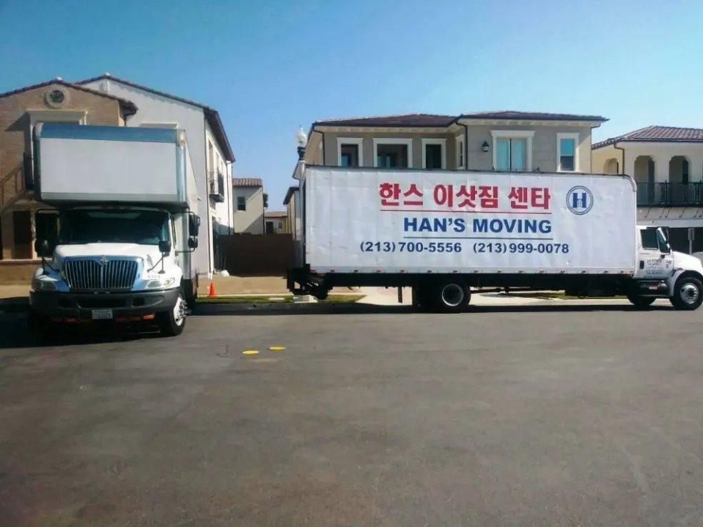 Han's Moving trucks parked together on a job site